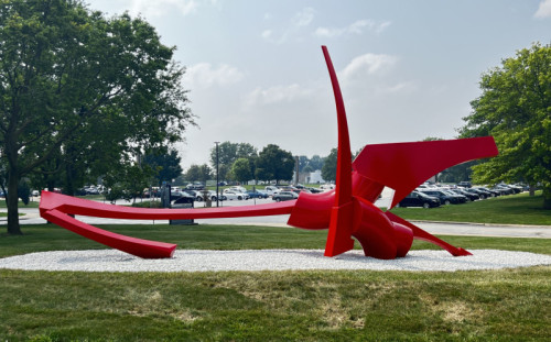 A large red steel sculpture called Transit Part I by Andrew Light at Governors State University's Nathan Manilow Sculpture Park