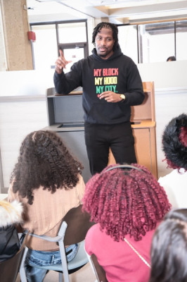 A young black man sharing his life's mission with high school students