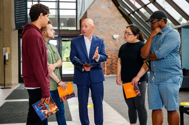 A man giving four people a tour of Governors State University
