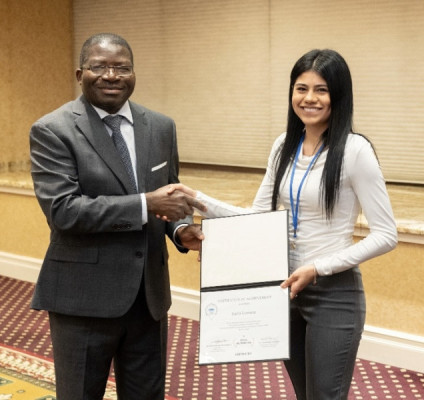 A woman receiving a certificate and shaking hands with a man