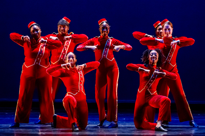 Seven people performing a dance on stage