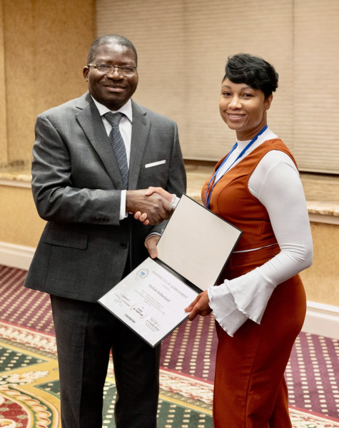 A woman receiving a certificate and shaking hands with a man