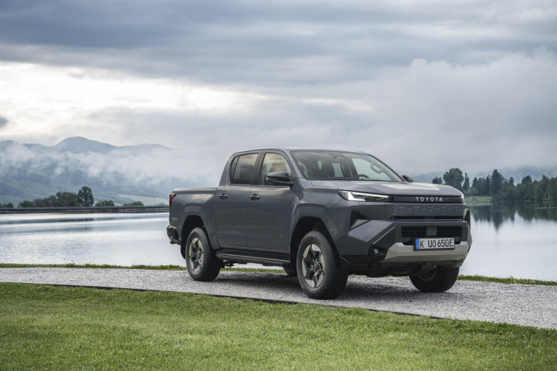 Official Toyota image of the 2026 Hilux BEV parked beside a lake
