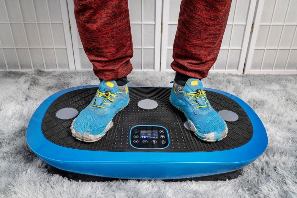 Vibration plate - Image of a vibration plate with two feet and legs visible. Vibration plate