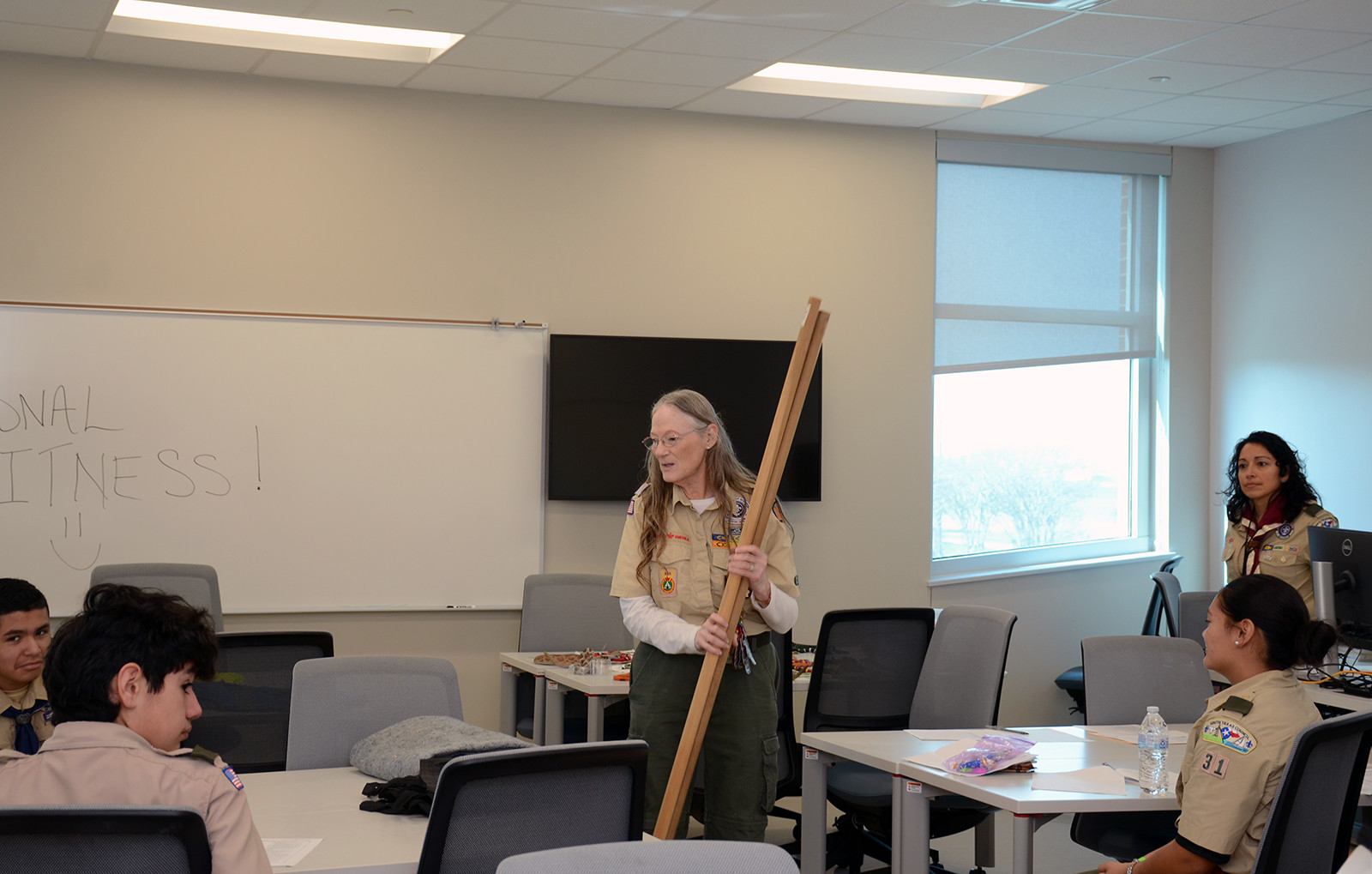 p-3Merit Band College 2026 - A Scoutmaster demonstrates the use of poles in fashioning an improvised stretcher during an activity at Merit Badge College. p-3Merit Band College 2026