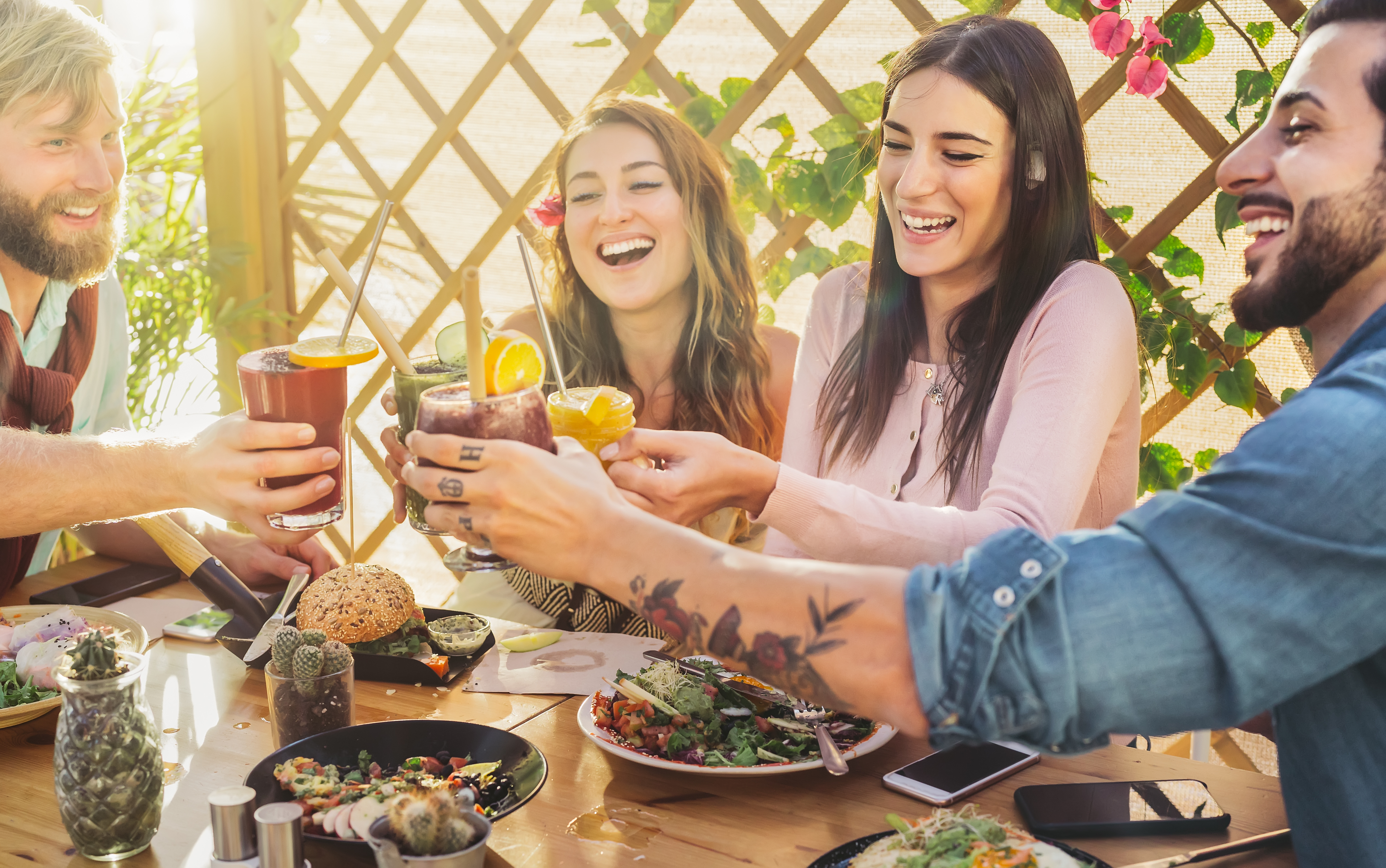 appy friends lunching healthy food and drinking smoothies fresh fruits