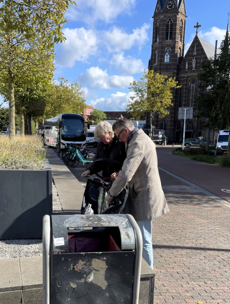 Smits en Hattink gooien het verzamelde afval in een vuilnisbak aan de straat.