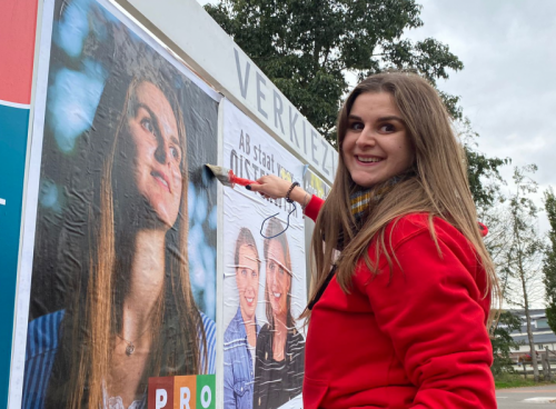 Myrthe Hesselberth plakt verkiezingsposters in Oisterwijk.