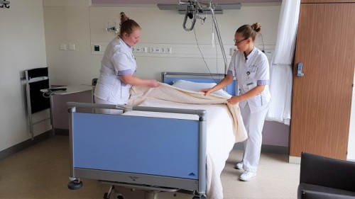Verpleegkundestudenten Demi Scheepers (links) en Myrthe van der Meijden maken op de afdeling cardiologie een bed op.