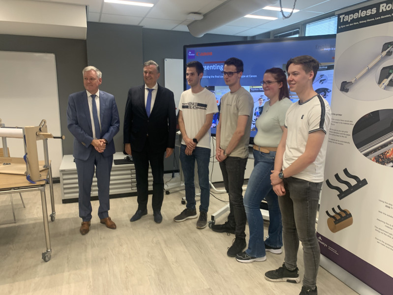 De bestuurders met de studenten die een succesvolle innovatie bedachten voor printers van Canon. 