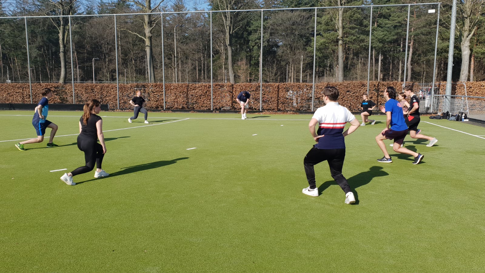 Er kan niet gesport worden zonder een goede opwarming. Je zou denken dat studenten Journalistiek alleen hun schrijfhand trainen, maar niks is minder waar. Na het stretchen van de kuiten werd hier flink getraind aan de benen en billen. 