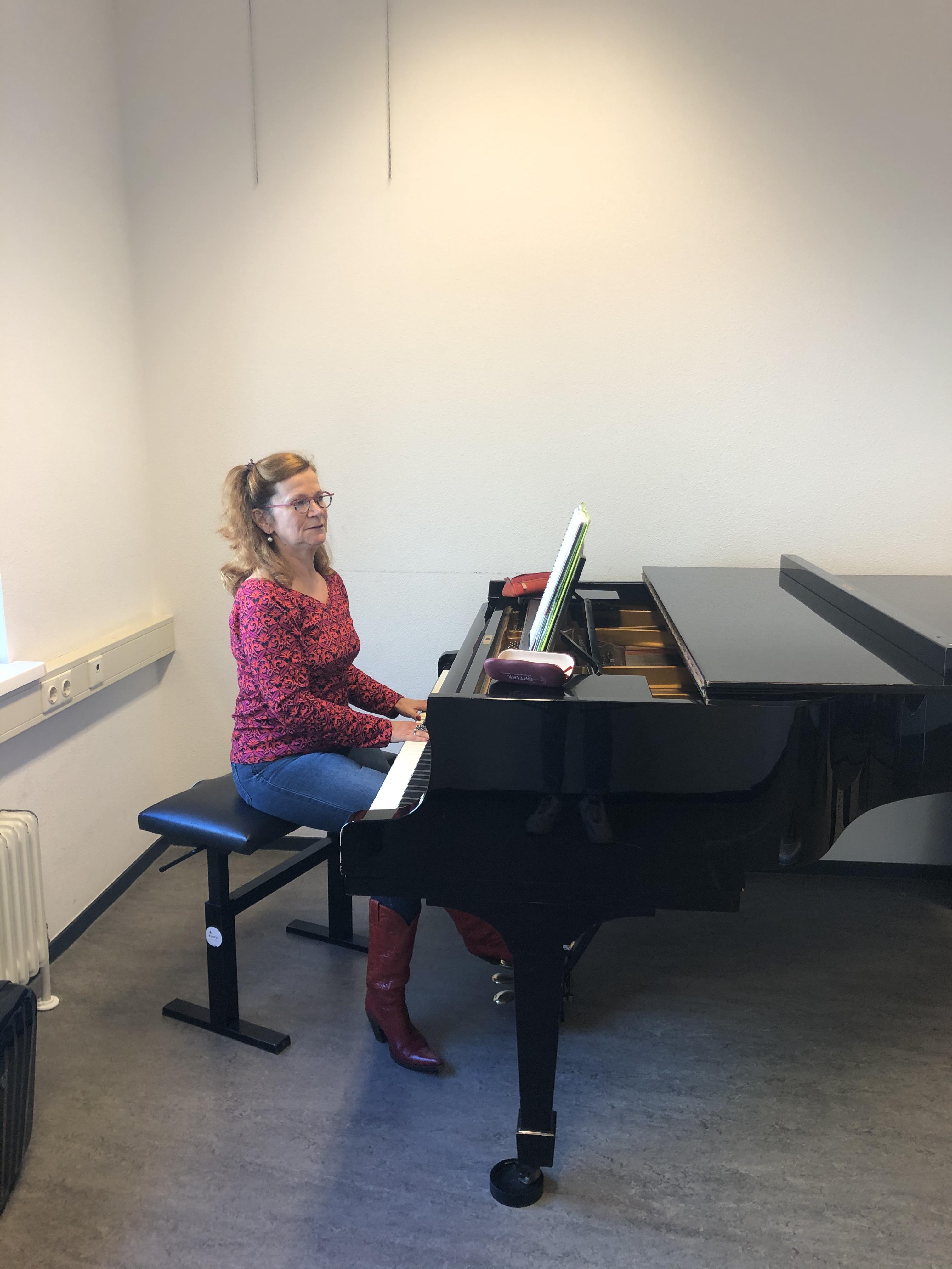 Zangdocent Peggy Hegeman begeleidt studenten op de piano.