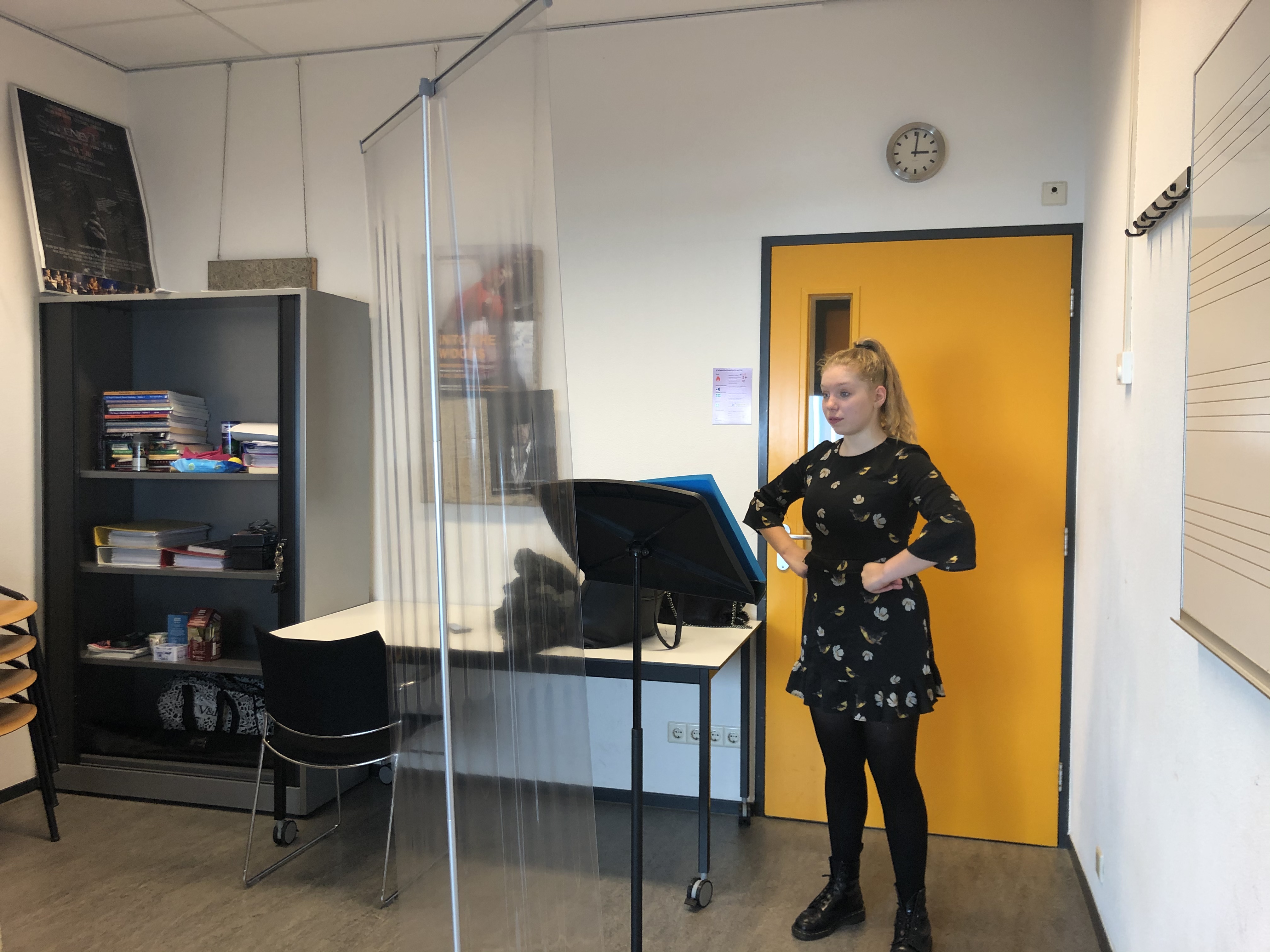 Tijdens de zangles bij staat er een scherm tussen student Bella en de docent.