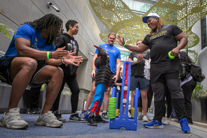 Rams rookie players playing a game of Connect Four with Guerin Children's patient, Justus Blakemore. Photo by Cedars-Sinai.