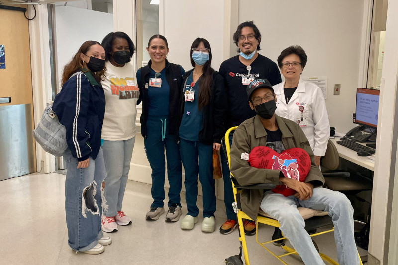G'bari Gilliam, seated, surrounded by family and members of his care team.