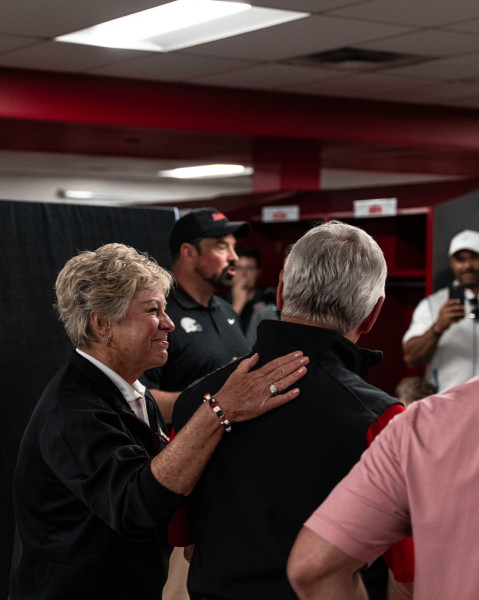 Ellen Tressel congratulates her husband Jim as Ohio State Head Football Coach Ryan Day speaks about Tressel's legacy