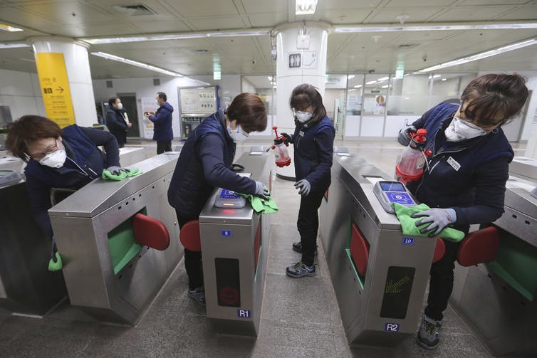 Employees disinfect ticket gates in South Korea.