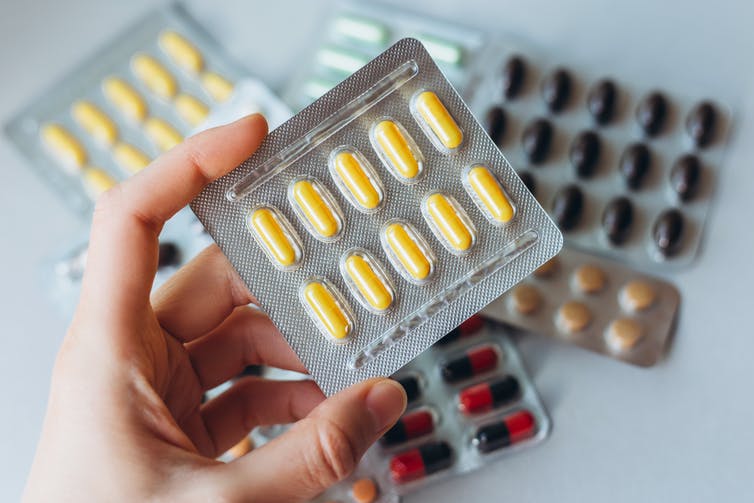 Person holding pills in blister packs