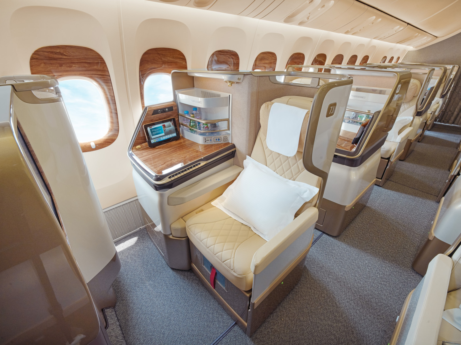An empty Emirates Boeing 777 business class cabin photographed from the aisle.