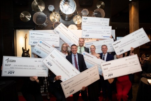 Giving Joy Winners - Ashley Kuzma (left), Jason Seaman (center) and Nicole Conlisk (right of center) celebrate with NCL President and CEO Andy Stuart (left of center) and nationally syndicated radio personality, Elvis Duran (right), with $100,000 in donations made by Norwegian Cruise Line and its partners and friends Giving Joy Winners