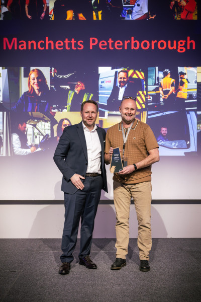 Jan Kohlmeier, Managing Director of MAN Truck & Bus UK Ltd, presents Peter Bradshaw, Branch Manager at Manchetts Peterborough, the MAN Truck & Bus UK Ltd’s 2025 Dealer of the Year trophy.