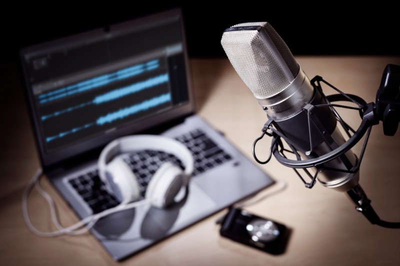 stock-photo-podcast-microphone-laptop-computer-camera-and-headphones-on-desk-in-recording-studio-1974798173.jpg