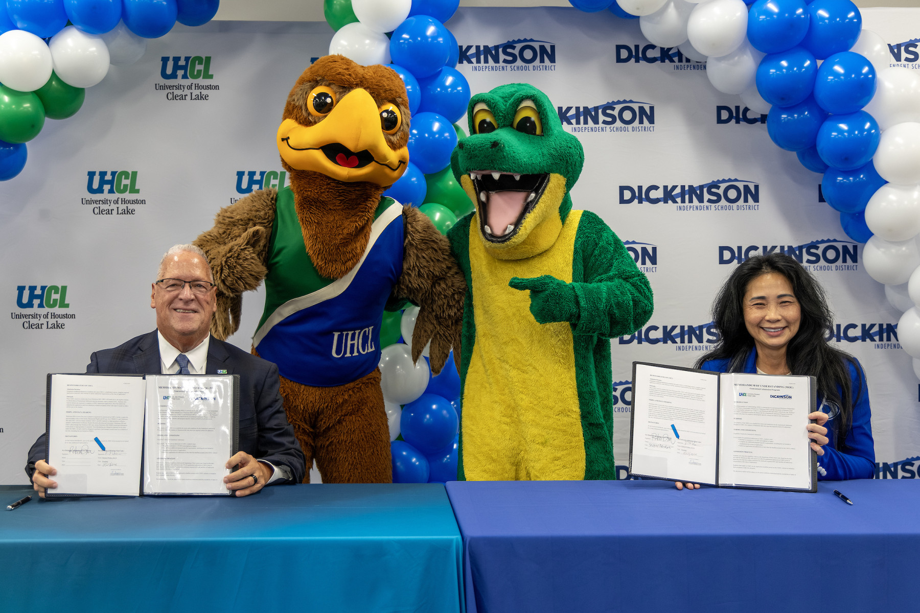 University of Houston-Clear Lake President Richard Walker, left, and Dickinson ISD Superintendent Dr. Rebecca Brown celebrate the new Guaranteed Admission partnership with UHCL’s Hunter the Hawk and the Dickinson Gator. The agreement creates a direct pathway to UHCL for eligible Dickinson ISD students beginning with Fall 2027 applicants.