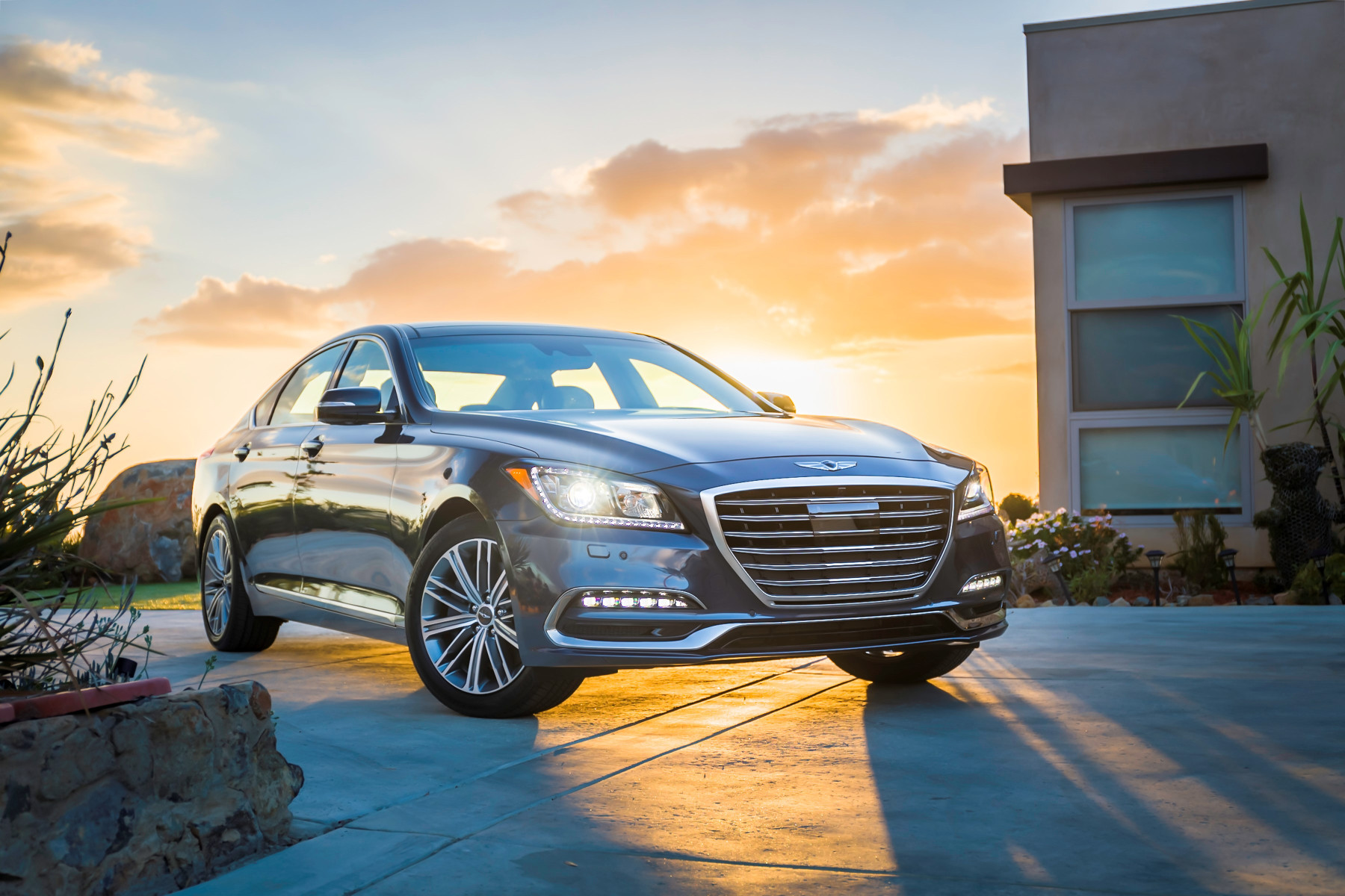 A dark gray 2017 Genesis G80 sedan parked at sunset, one of the model years in recall 26V-664