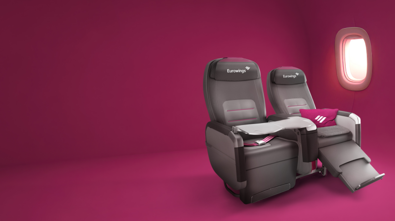 Sedili Premium BIZ di Eurowings, design ergonomico con schienali regolabili, disposti in una configurazione 2x2, su uno sfondo rosa.