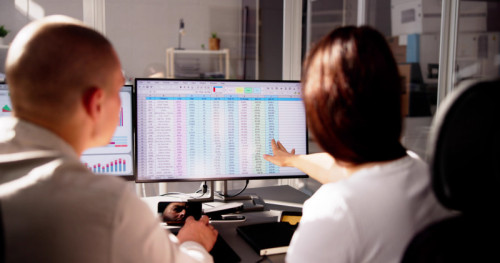 Analyst Employee Working On Spreadsheet Using Desktop Computer