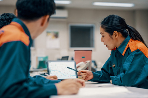 Medium shot of three firefighters discussing a digital map in the fire department