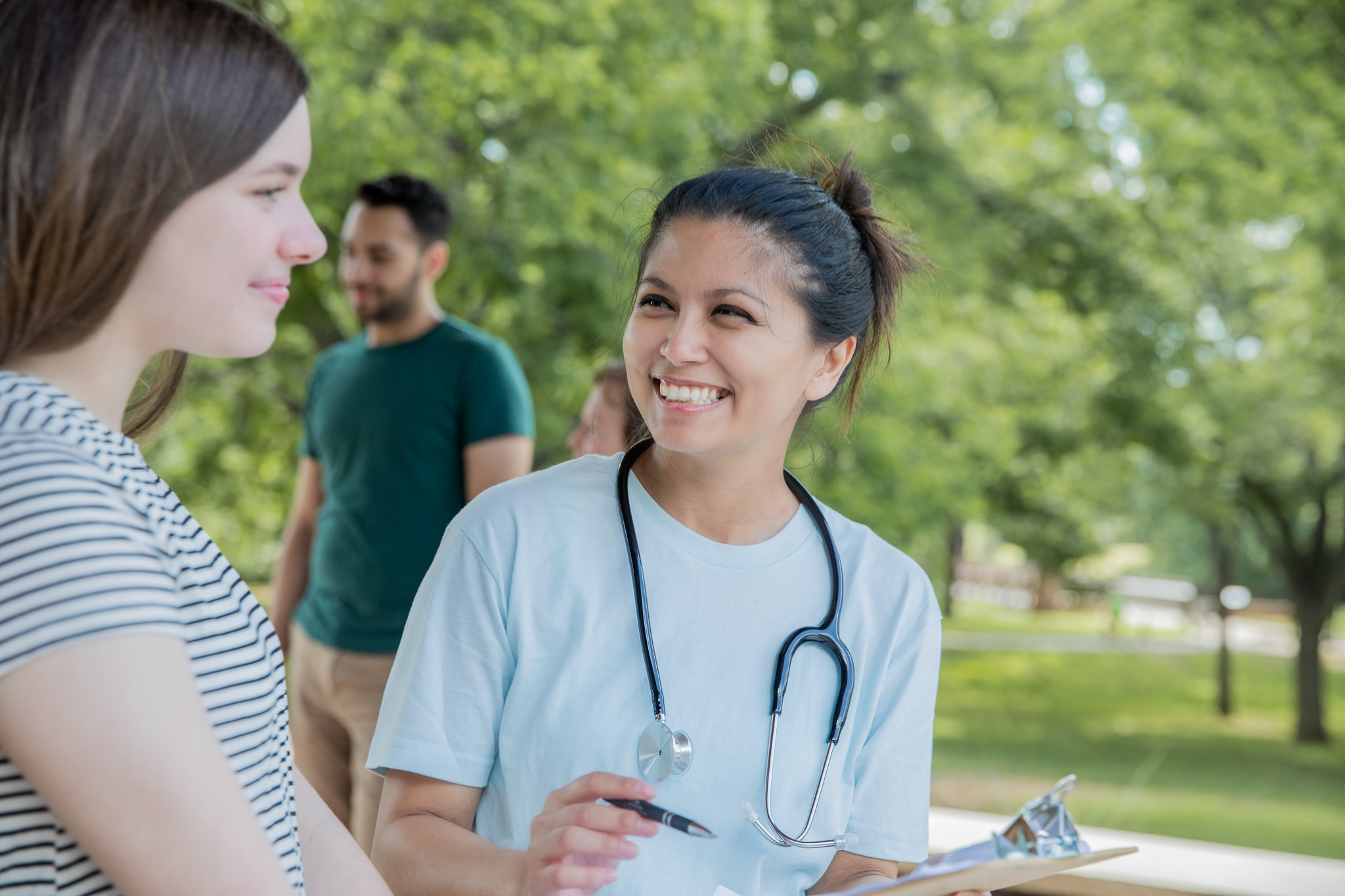 Nurse talking to teenager during free healthcare event