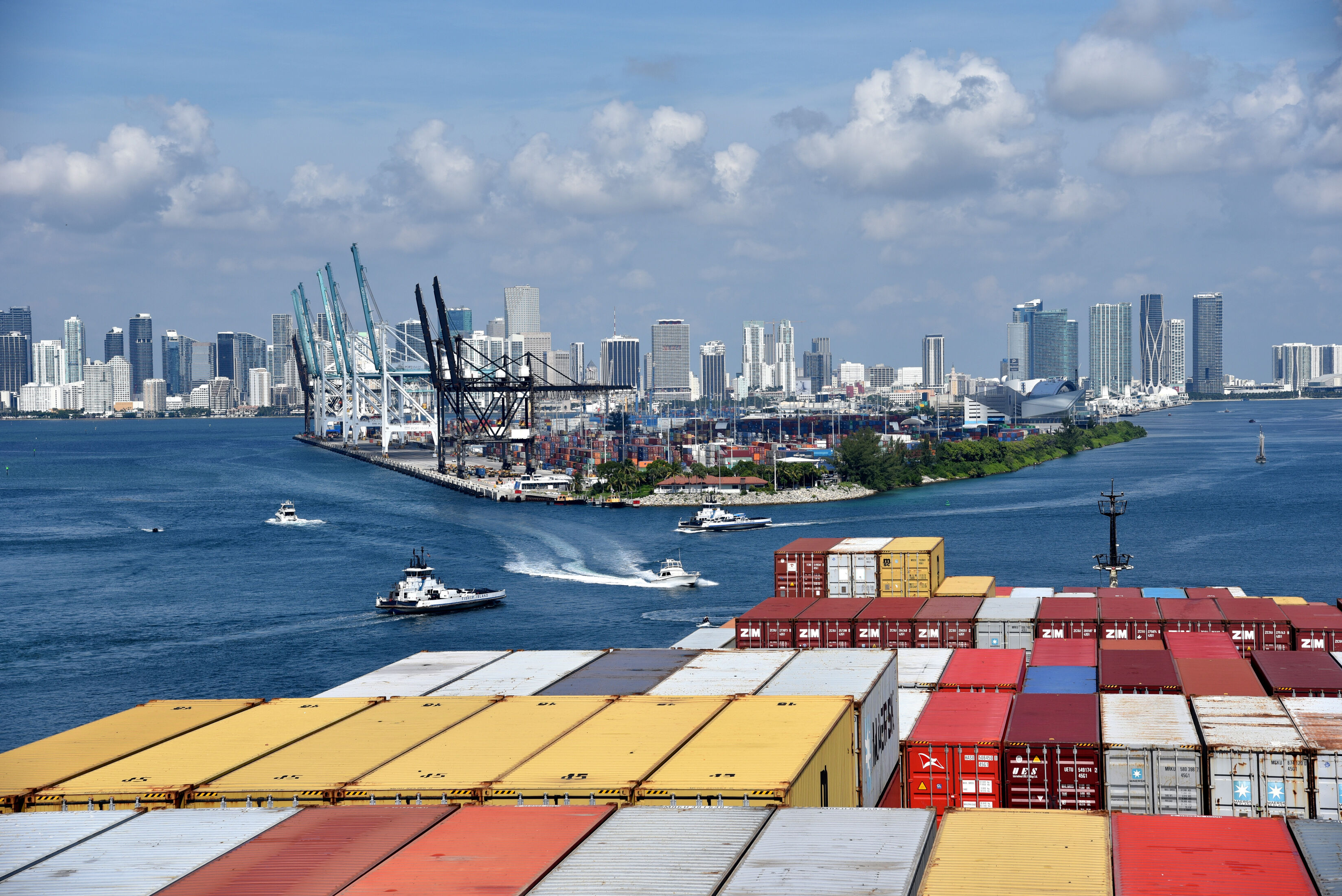 Shipping containers and vessels at Miami port with cranes and skyline, highlighting U.S. cross-border trade and logistics.